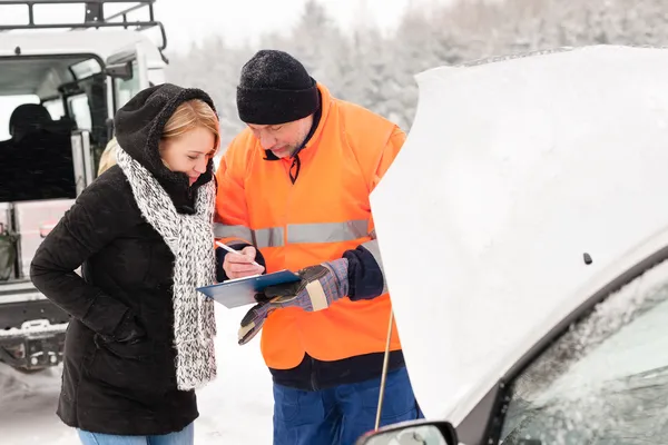 Vrouw opvulling document gebroken auto sneeuw mechanic — Stockfoto