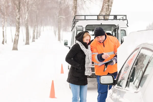 Женщина заполнить документ сломанный автомобиль снежный механик — стоковое фото