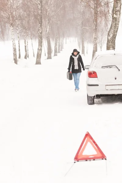 Vrouw lopen met gas kan auto sneeuw — Stockfoto