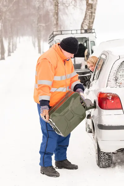 Man filling woman car gas winter assistance Royalty Free Stock Photos