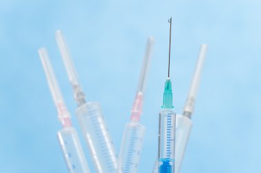 Syringes with liquid drop falling from needle clipart