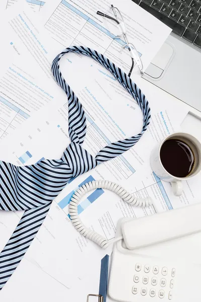 Busy office desk tie on paper charts — Stock Photo, Image