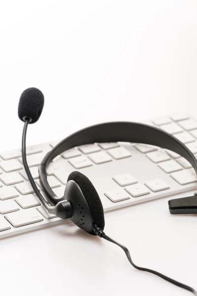 Auriculares de oficina con teclado de micrófono en el escritorio — Foto de Stock