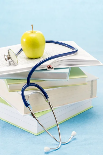 Медицинские книги, яблоко и стетоскоп — стоковое фото