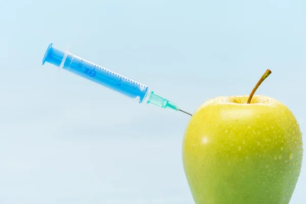 Groene appel en spuit genetisch gemodificeerde levensmiddelen — Stockfoto