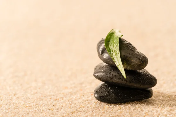 Spa zen pedras com folha na areia — Fotografia de Stock