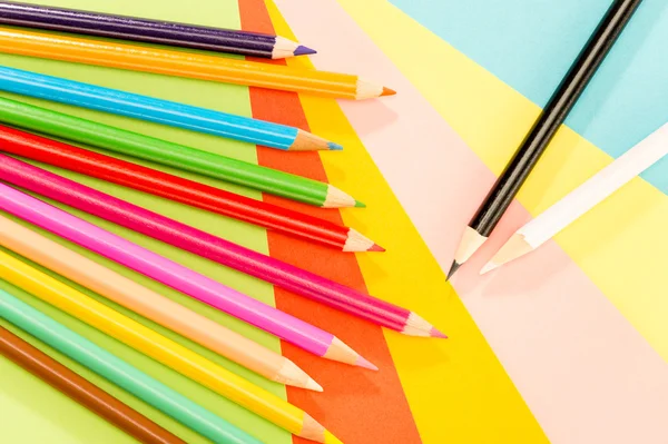 Color pencils on colorful papers close-up — Stock Photo, Image