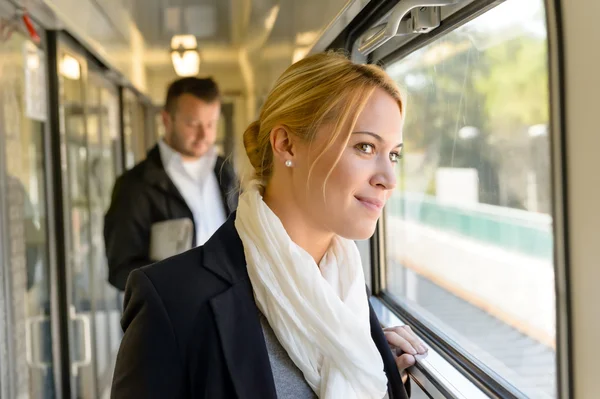 Mujer en tren mirando pensativo en ventana — Foto de Stock