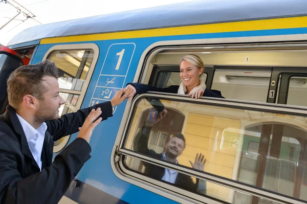 Man saying goodbye to woman on train — Stock Photo, Image