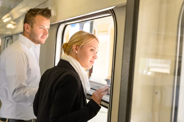 Woman and man looking out train window — Stock Photo, Image