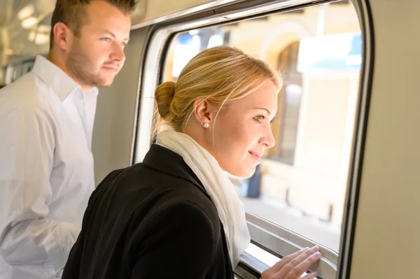 Man and woman looking out train window — Stock Photo, Image