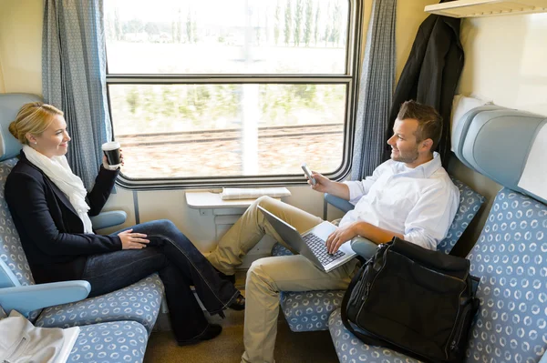 Homem e mulher sentados no trem conversando — Fotografia de Stock