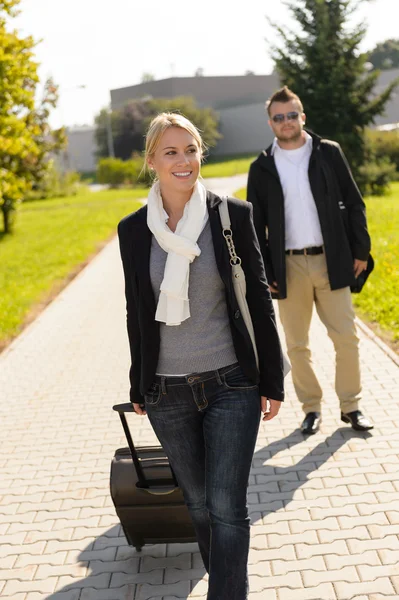 Woman leaving with baggage man walk behind — Stock Photo, Image