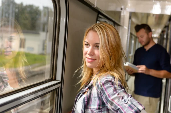 Mulher olhando pela janela do trem sorrindo — Fotografia de Stock
