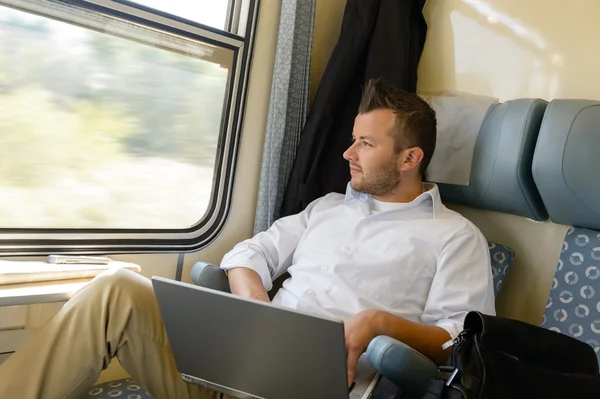 Man looking out the train window laptop — Stock Photo, Image