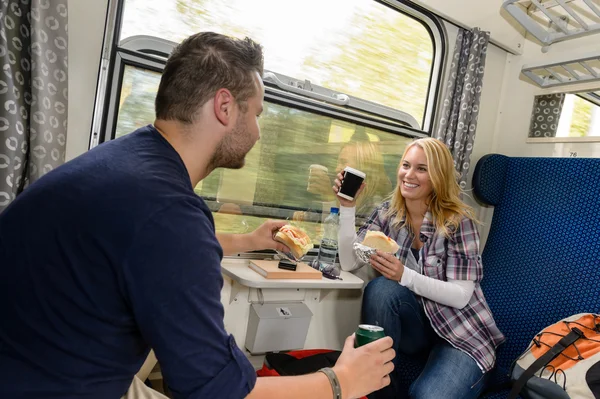 샌드위치와 함께 기차 여행을 즐기는 커플 스톡 사진