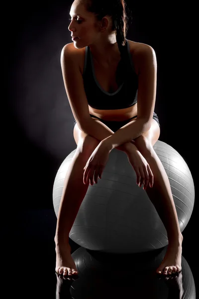 Joven mujer deportiva relajándose en la pelota de fitness —  Fotos de Stock