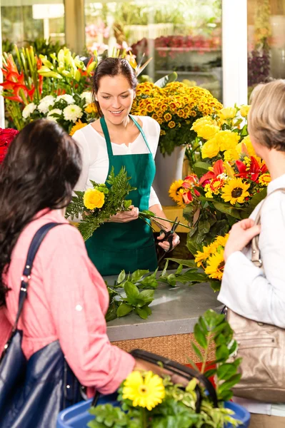 Jeune femme fleuriste coupe boutique de fleurs clients — Photo