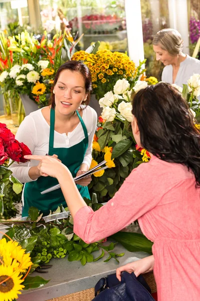 Unga florist beställning rosor kvinna kund blomma — Stockfoto