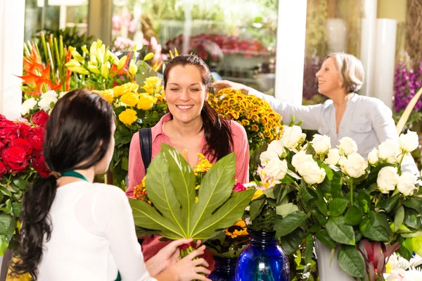 Jonge vrouw kopen boeket bloemen winkel klant — Stockfoto