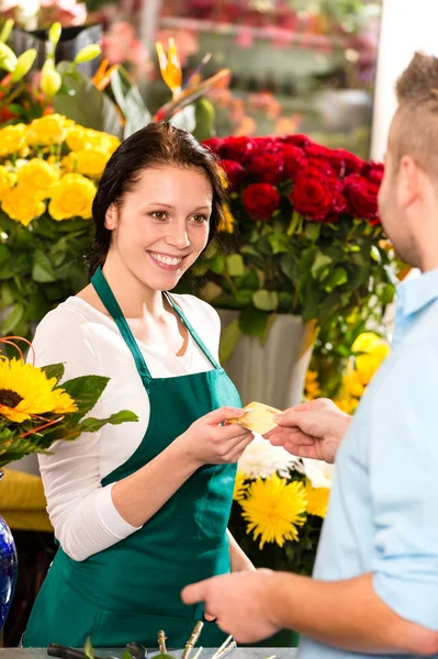 Улыбающийся цветочник покупает открытку с цветами — стоковое фото