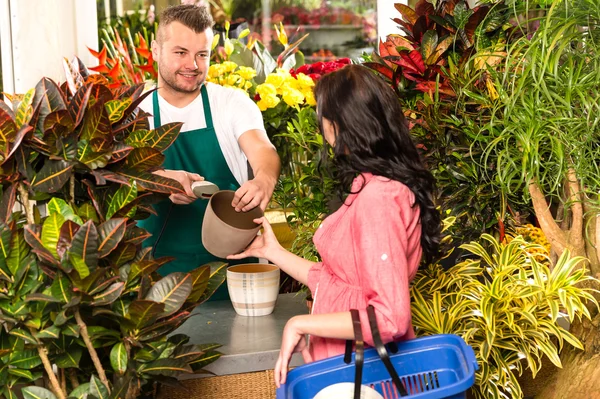 Man verkopen pot vrouw klant bloemenwinkel — Stockfoto
