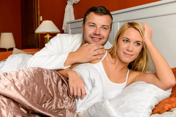 Usmívající se muž drží ženu ležící postel ženatý — Stock fotografie