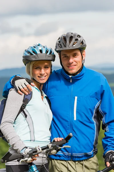 Jeune couple sportif avec des vélos de montagne en casque — Photo