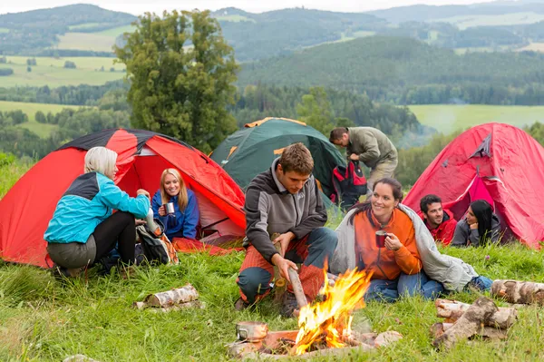 Vergadering door kampvuur vrienden in tenten chatten — Stockfoto