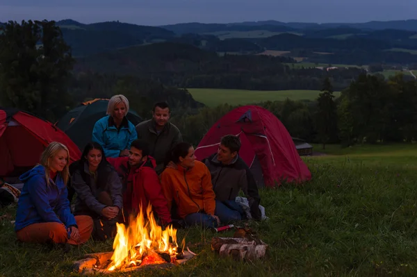 Campeggio guardando il falò insieme accanto alle tende — Foto Stock