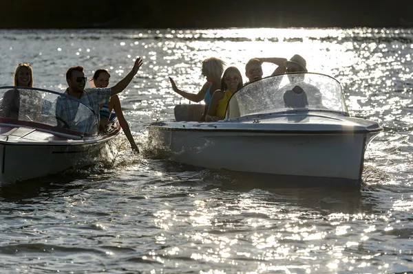 Sylwetka młodych przyjaciół w łodzi motorowych — Zdjęcie stockowe