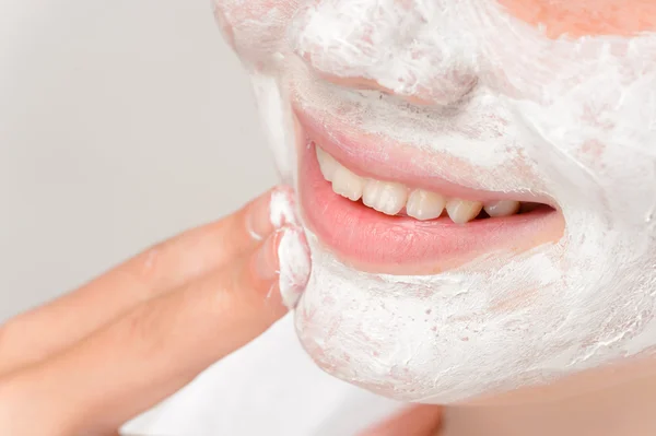 Ragazza sorridente mettendo maschera facciale dita pulizia — Foto Stock