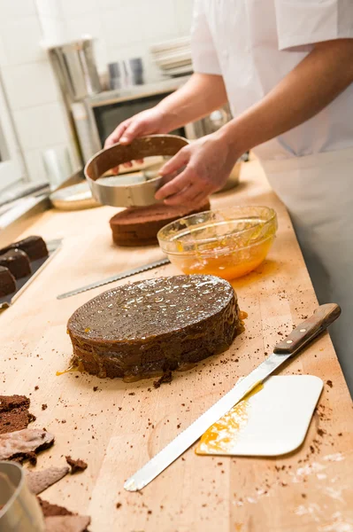 Cozinheiro tirando bolo da forma de bolo — Fotografia de Stock