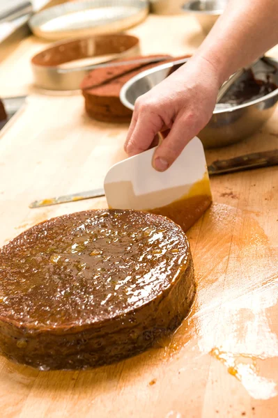 Mužský šéfkuchař zdobí čokoládový dort v kuchyni — Stock fotografie