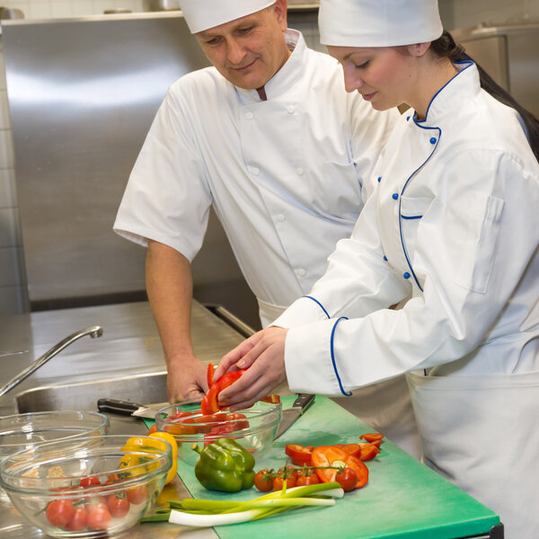 Female and male cooks preparing salad in restaurant's kitchen