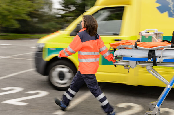 Blurry paramedics pulling gurney ambulance car