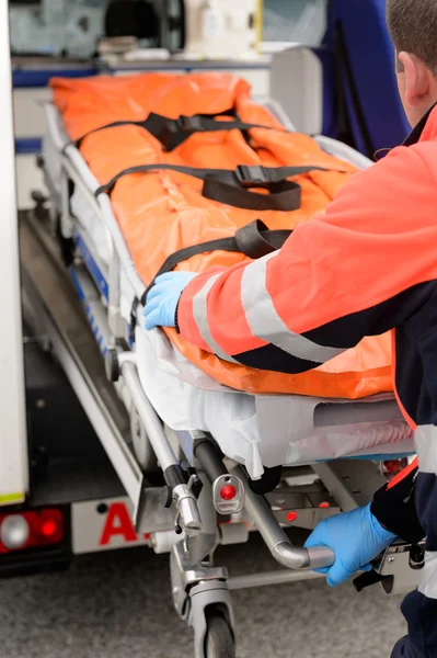 Paramedic rolling out gurney from emergency truck — Stock Photo, Image