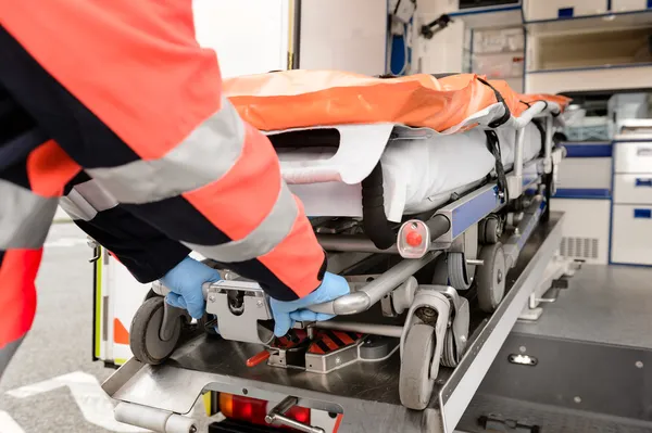 Paramedic pulling out gurney from ambulance car — Stock Photo, Image