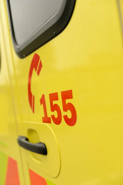 Número de telefone da equipe de resgate carro de ambulância amarelo — Fotografia de Stock