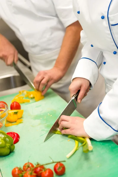 Close up de chefs cortando legumes Fotografia De Stock