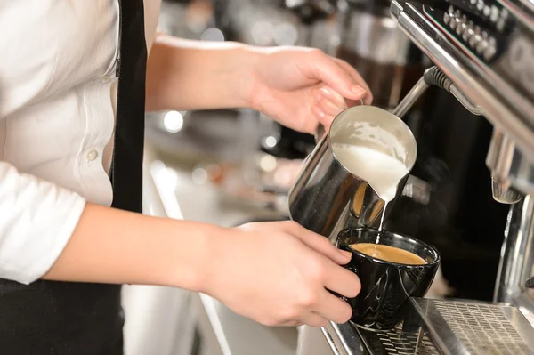 Camarera manos verter la leche haciendo capuchino — Foto de Stock