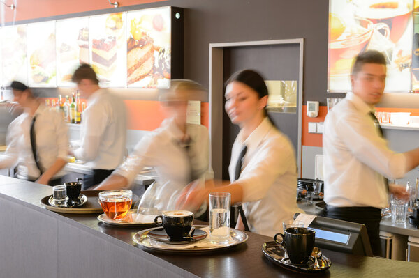 Busy waiter and waitresses working at bar