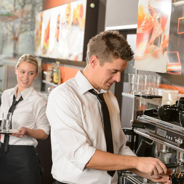 Young waiter and waitress working in bar