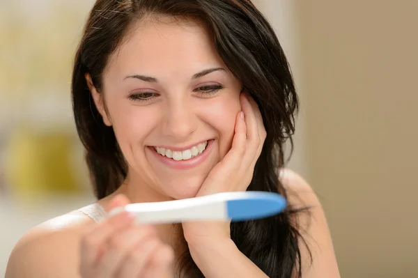 Mujer encantada sosteniendo prueba de embarazo Imagen de stock