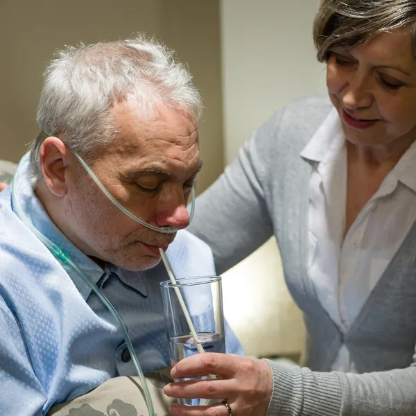 Pielęgniarka pomoc starszy człowiek chory z picia — Zdjęcie stockowe