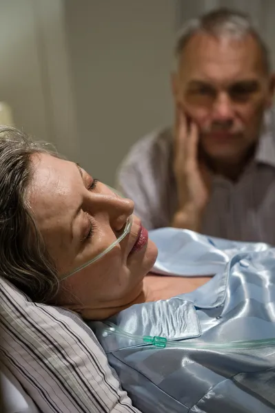 Dying woman in bed with caring man — Stock Photo, Image