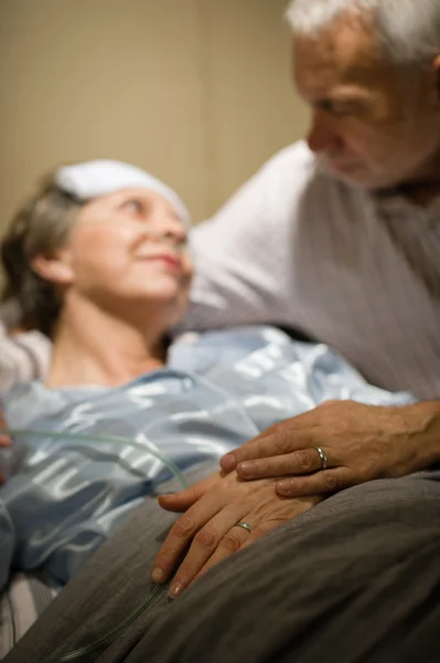 Ηλικιωμένο ζευγάρι, κρατώντας τα χέρια στο θάλαμο κλινική — Φωτογραφία Αρχείου