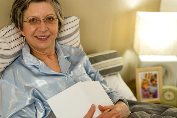 Idős asszony feküdt az ágyban pizsama — Stock Fotó