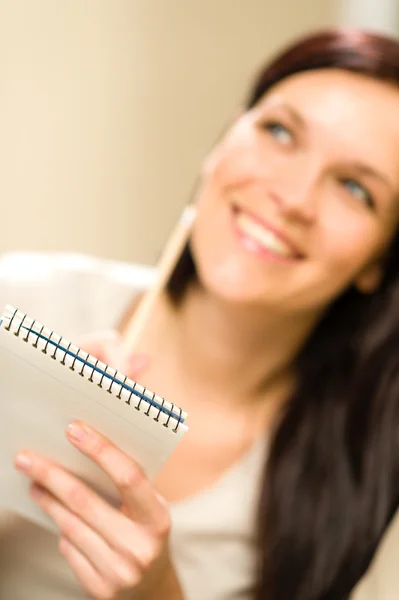 Sorrindo pensando mulher segurando bloco de notas — Fotografia de Stock