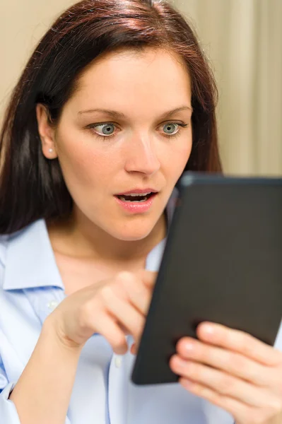 Förvånad kvinna läser på digitala tablett — Stockfoto